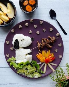 a purple plate topped with food and vegetables