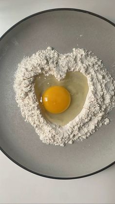 a heart shaped egg in flour on a plate