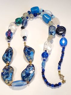 "Beautiful collection of glass and stones. The array of blue colors give an elegance with this necklace. Center pieces of pendant are 4 abstract shape copper metal, with beautiful colors of dark blue,and light blue enamel with exposed copper, in a high gloss finish. Each metal piece measuring 1.5\" wide. Along with clear and frosted large beads, connecting to blue clear glass beads. Several agate gemstone beads Accent beads of multifaceted design, along with accent blue beads Turquoise large blu Costume Jewelry Necklaces With Polished Czech Glass Beads, Costume Jewelry Necklaces With Czech Glass Polished Beads, Blue Costume Jewelry With Stones, Blue Polished Beads Jewelry, Blue Czech Glass Necklaces With Gemstone Beads, Blue Czech Glass Spiritual Necklace, Bohemian Blue Czech Glass Necklaces, Blue Spiritual Czech Glass Necklace, Spiritual Blue Czech Glass Necklace