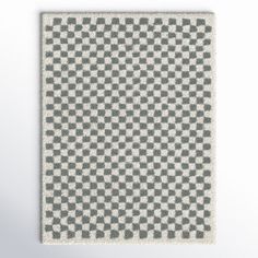 a gray and white checkered area rug on a wall with a light grey background