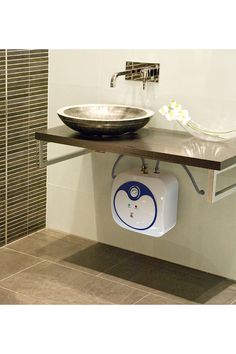 a bathroom with a sink, mirror and soap dispenser on the wall