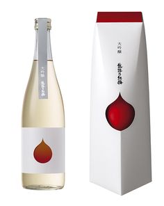 a bottle of wine next to a white box with a red design on the side