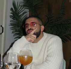 a man sitting at a table with two glasses in front of him