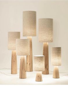 several lamps made out of wood and fabric shades