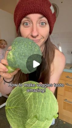 a woman holding up a head of cabbage in her kitchen with the caption how to make veggies taste amazing