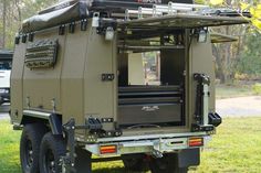 an army vehicle parked in the grass with its doors open