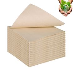 a stack of cloths sitting on top of each other next to a hand holding a green leaf