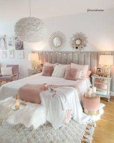 a bedroom decorated in pink and white with gold accents