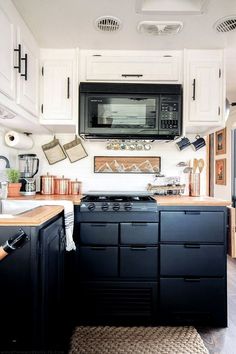 a black and white kitchen with lots of cabinet space in the middle, including an oven