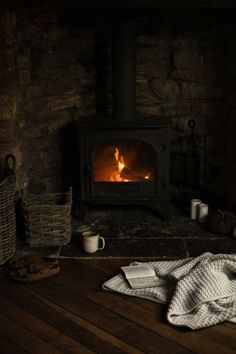 a blanket is on the floor in front of an open fire