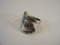 two silver rings sitting next to each other on a white surface with one ring in the middle