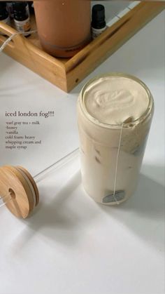 the contents of an iced london fog in a glass jar and wooden spools