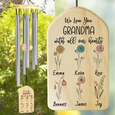 a wooden wind chime hanging from a tree next to a memorial plaque that reads, we love you grandma with all our hearts