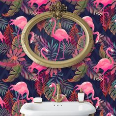 flamingos and palm leaves are featured in this bathroom wallpaper design with a gold framed mirror