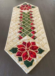 a table runner with red and green flowers on it