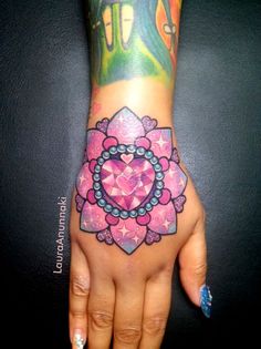 a woman's hand with tattoos on it and a pink flower in the middle