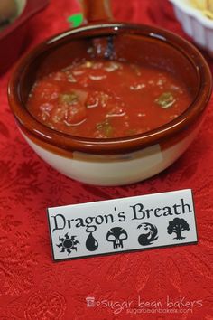 a bowl of soup on a red table cloth with a sign that says dragon's breath