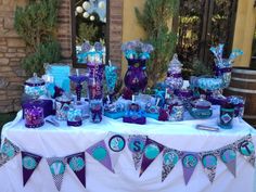 a table topped with lots of purple and blue items