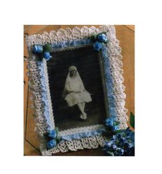 an old photo with blue flowers on the edge and a white lace border around it