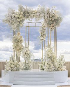 an outdoor ceremony setup with white flowers and greenery