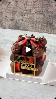 a happy birthday cake with strawberries and chocolates