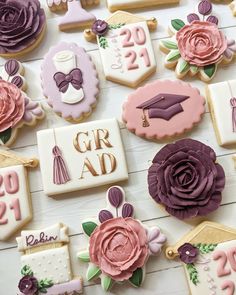 decorated cookies are arranged on a table with flowers and graduation decorations in the background,