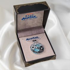 a necklace in a box on a white cloth covered surface with the name avatar printed on it