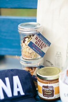 jars of food are sitting on a table with a baseball cap and blue hat next to it