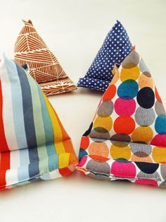 three different colored pillows sitting next to each other