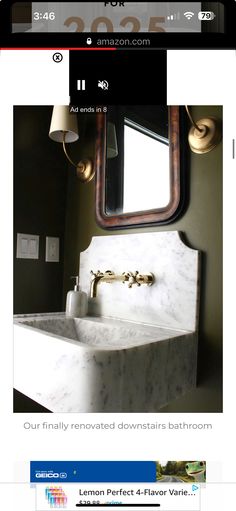 a bathroom sink sitting under a mirror next to a wall mounted faucet in a bathroom