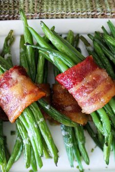 bacon wrapped green beans on a white plate