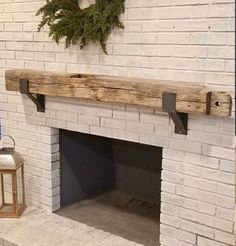 a white brick fireplace with a wreath on the mantel above it and a lantern