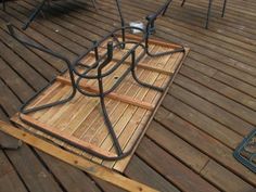 a wooden deck with metal railings and chairs