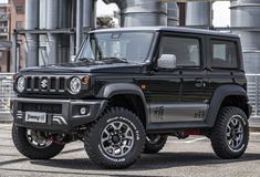 a black jeep is parked in front of an industrial building