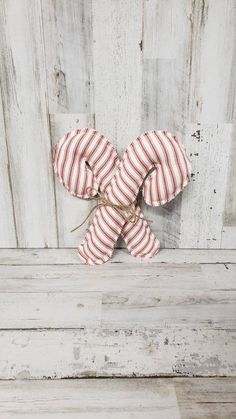 a red and white striped bow tied to a wooden wall