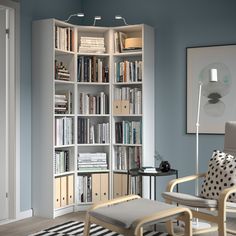 a living room filled with lots of books and furniture