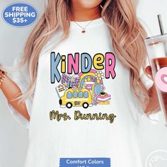 a woman wearing a white shirt with the words kinder mrs running on it and a drink in her hand