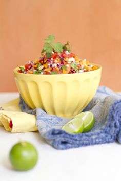 a yellow bowl filled with rice and garnished with cilantro, red onion, green onions and lime