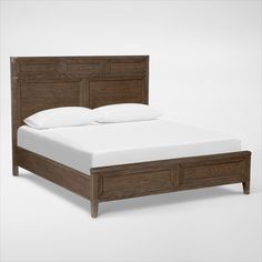 a bed with white pillows and wooden headboard on top of it's frame