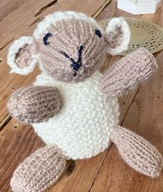 a knitted stuffed animal sitting on top of a wooden table