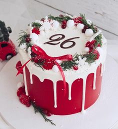 a cake decorated with white icing and red decorations