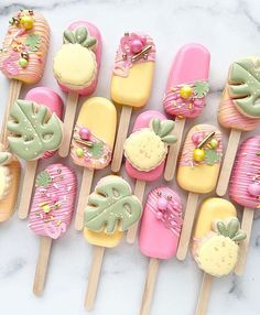 there are many different colored pops on the sticks with flowers and fruit designs in them