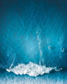 two surfers are riding the waves on their surfboards in the blue ocean water