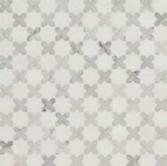 a white and grey tiled wall with an interesting pattern on it's surface,