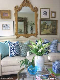 a living room with blue and white decor on the walls, couches and mirrors