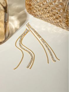 Sparkling Streamers: Dangle Earrings for Every Occasion Step into a world of timeless elegance where delicate chains adorned with sparkling rhinestones and cascading down to a radiant teardrop crystal transform your everyday into a fashion runway. These exquisite earrings, crafted from high-quality, 18K gold-plated stainless steel, are the epitome of grace and sophistication. Embrace the allure of Sparkling Streamers, a name that perfectly captures the essence of these captivating earrings.Envis Crystal Dangle Chain Jewelry, Long Drop Rhinestone Party Jewelry, Party Jewelry With Long Drop Rhinestones, Party Jewelry With Rhinestones In Long Drop Shape, Crystal Long Drop Linear Earrings, Party Long Drop Rhinestone Jewelry, Elegant Long Drop Crystal Earrings, Rhinestone Dangle Teardrop Earrings, Crystal Long Drop Chandelier Earrings