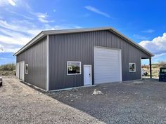 a large metal building with two garages on the side and one car parked in front