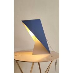 a table lamp sitting on top of a wooden table next to a blue and white wall