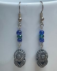 Fun Hippie Flower earrings! Cute antique silver charm with detail on both sides. Topped with tiny blue beads.