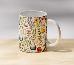 a coffee mug with flowers and plants on it